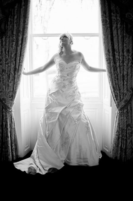 Bride standing in between curtains