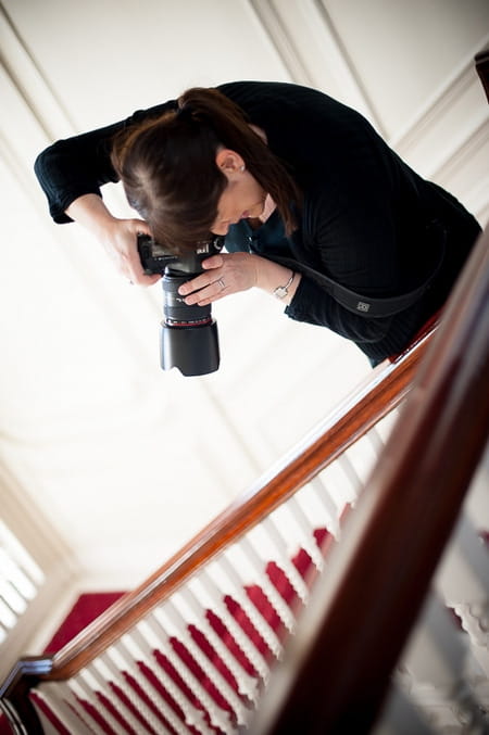 Photographer leaning over banister to take picture