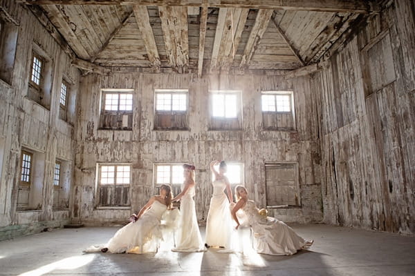 Four brides posing in warehouse