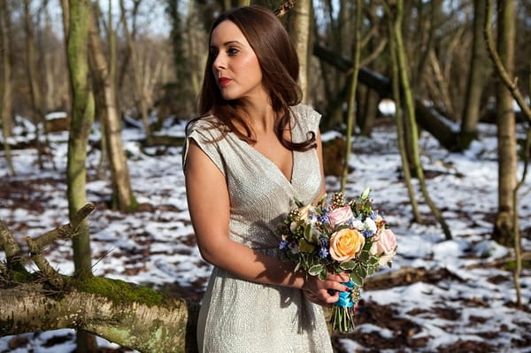 Bride in woods holding bouquet