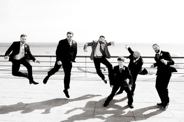 Groom and groomsmen jumping