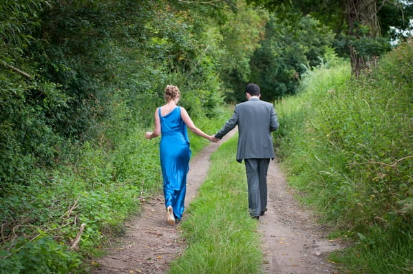 Bride and groom walking down country lane