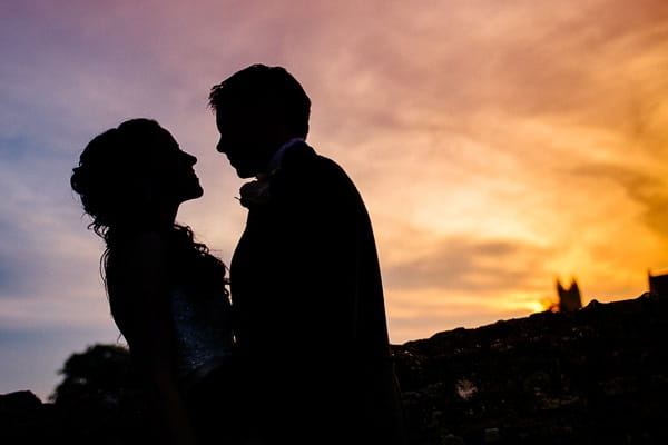 Bride and groom silhouette on colourful night sky