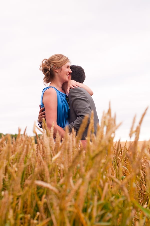 Bride and groom hugging in cornfield