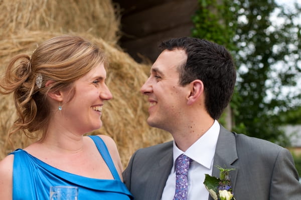 Bride and groom in front of hay bales