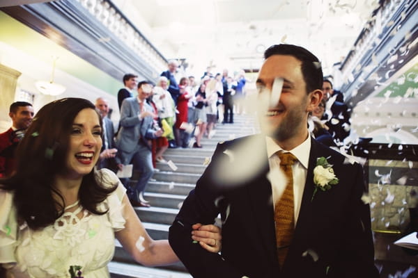 Bride and groom walking through confetti