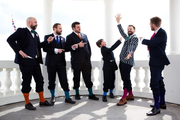 Groomsmen pointing at groom