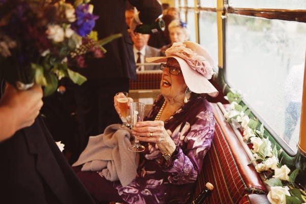Wedding guest drinking Champagne on bus