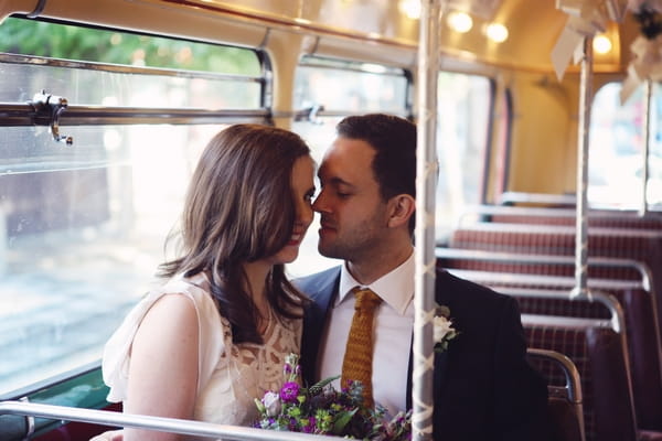 Bride and groom sitting on bus