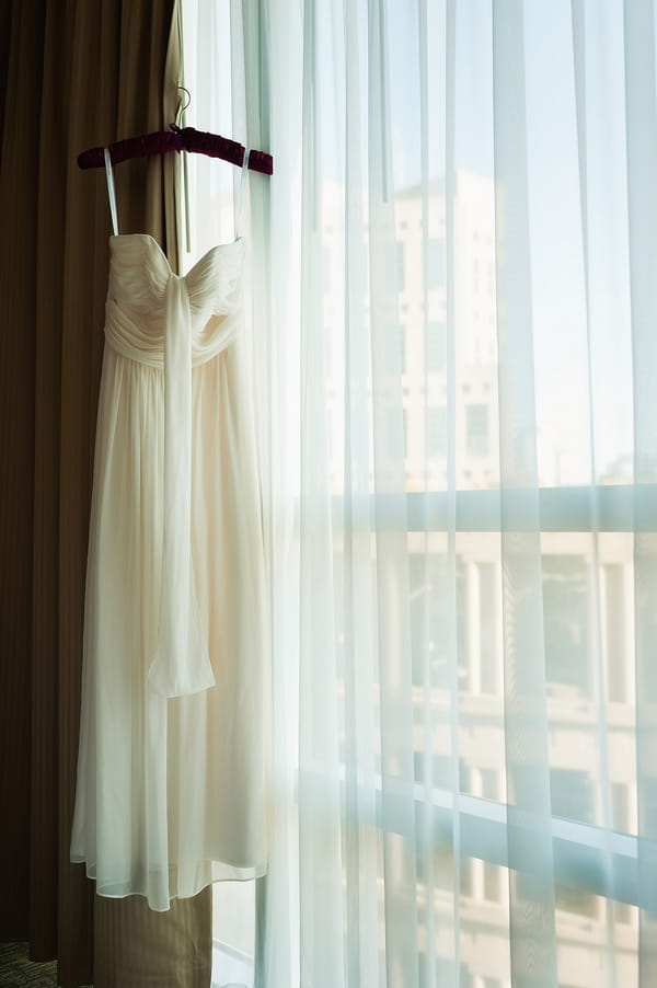 Wedding dress hanging by window