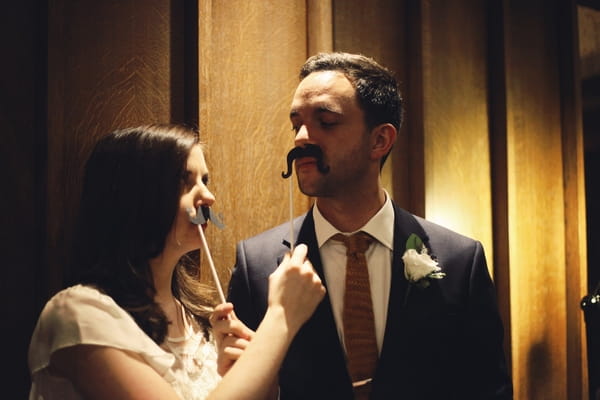 Bride and groom with false moustaches