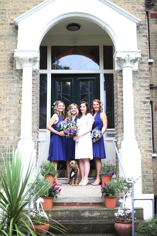 Bride and bridesmaids on steps outside house