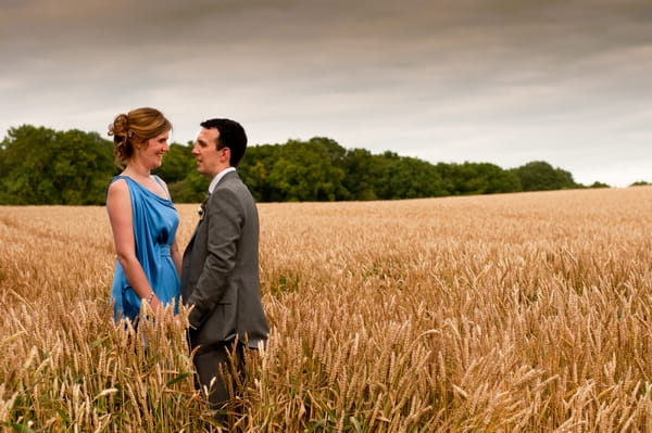 Bride and groom standing in cornfield