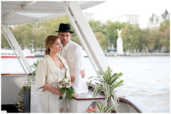 Bride and groom on boat looking out over Thames