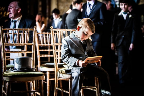 Young boy looking at order of service