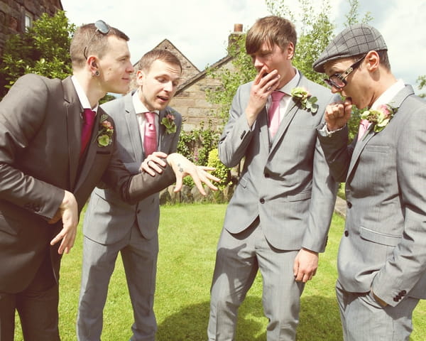 Groom showing groomsmen wedding ring