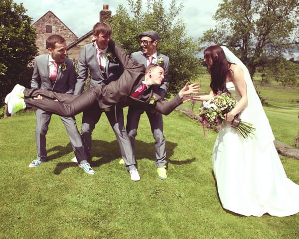 Groomsmen holding up groom