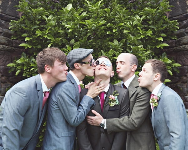 Groomsmen kissing groom