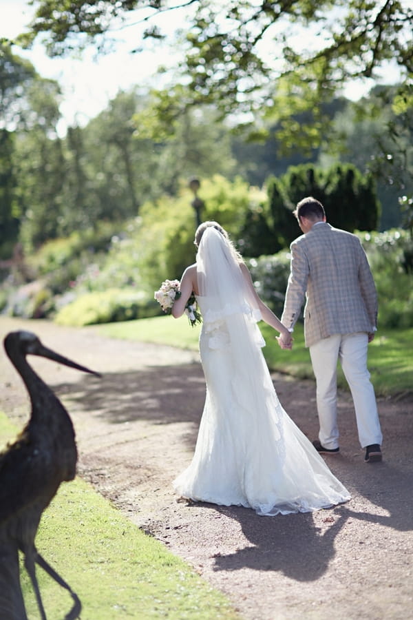 Bride and groom walking in gardens of Kirknewton Stables