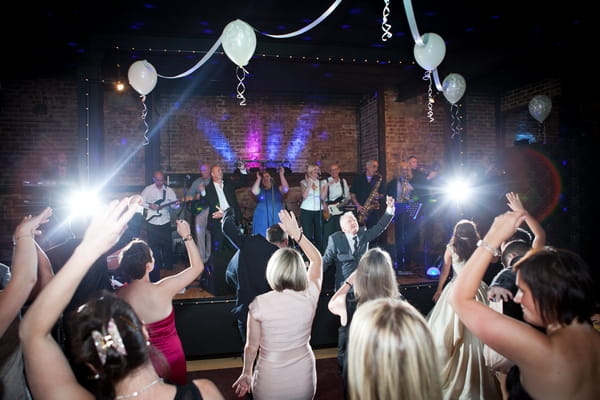 Wedding guests dancing to band