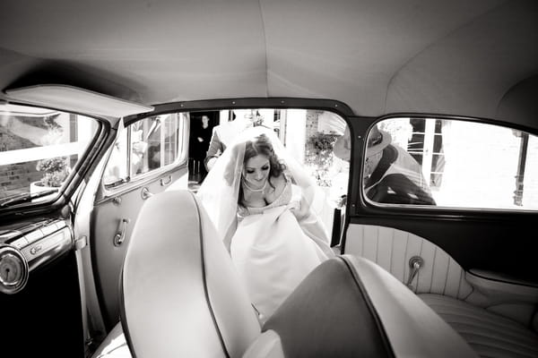 Bride getting into wedding car