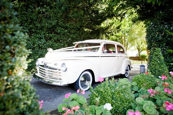 Vintage wedding car arrives at venue
