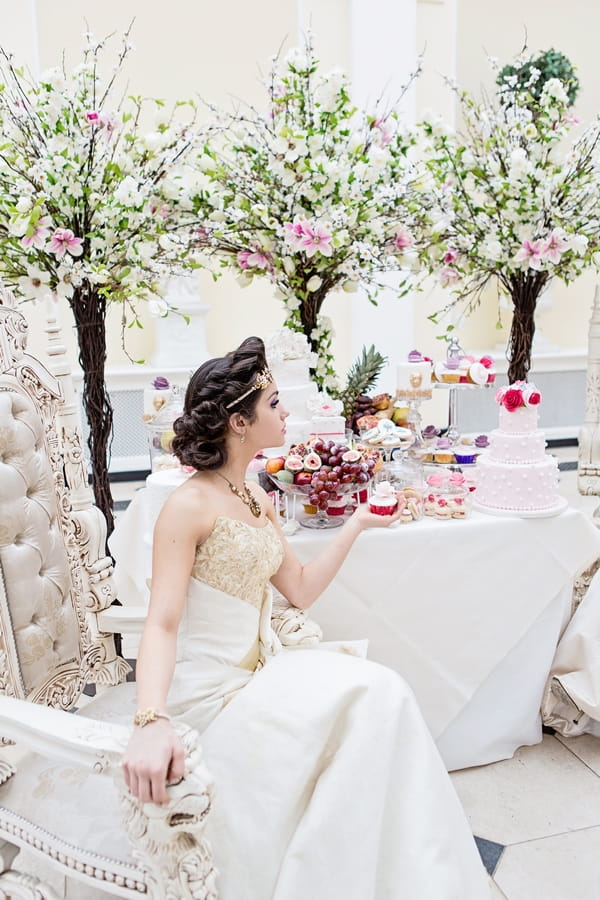 Bride sitting holding cupcake