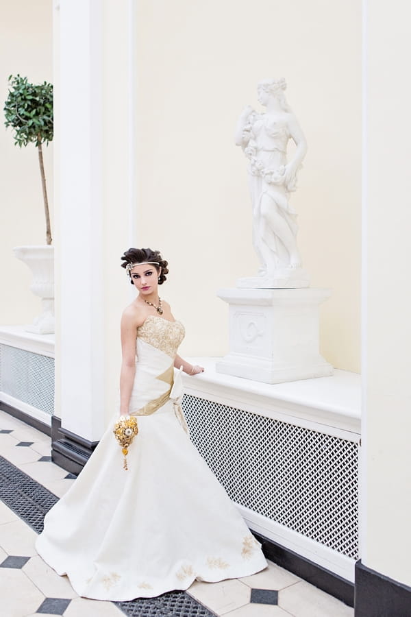 Bride standing next to statue