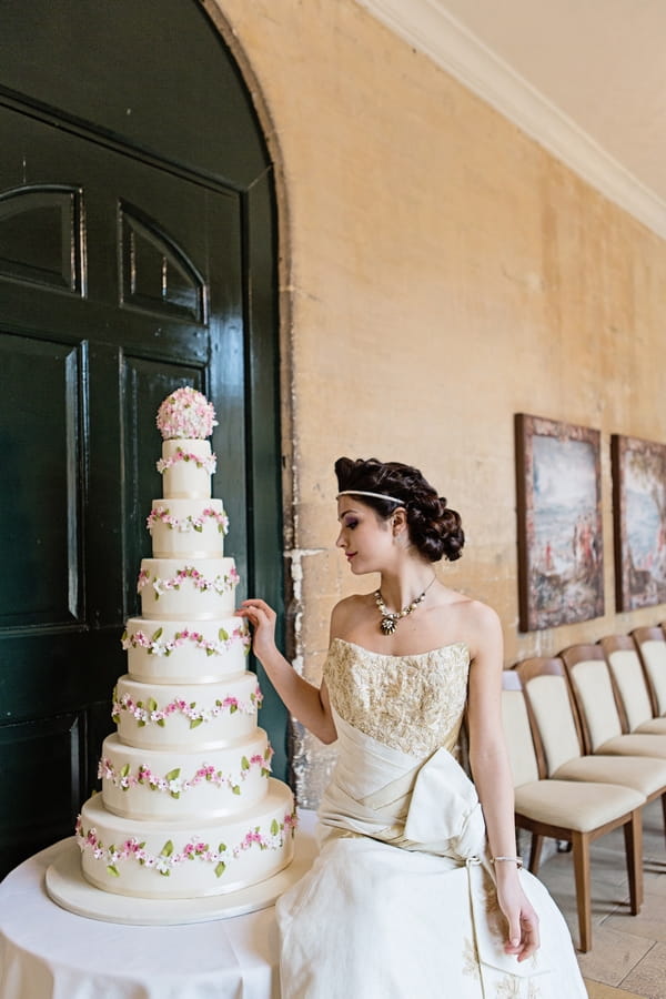 Bride next to tall wedding cake