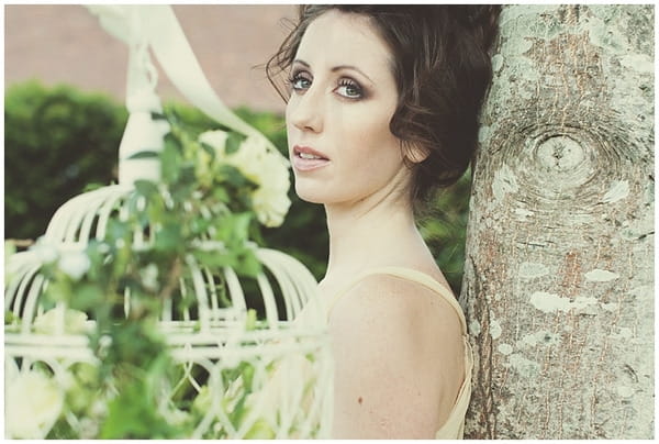 Bride leaning back on tree