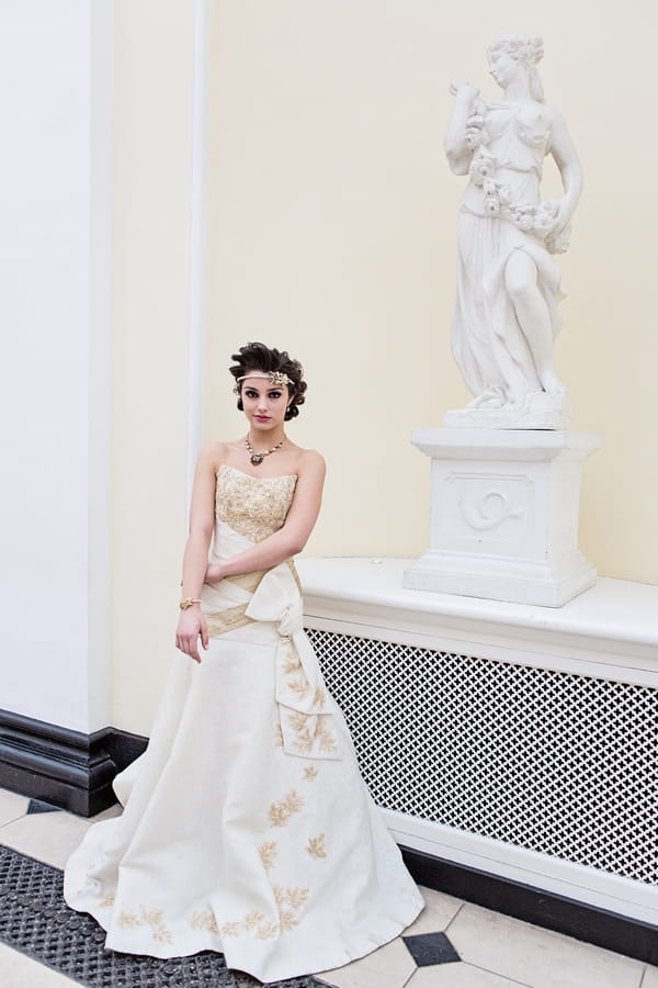 Bride standing by statue