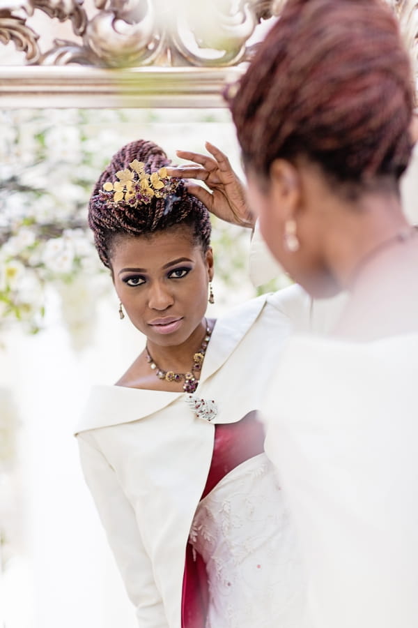 Bride adjusting headpiece in mirror