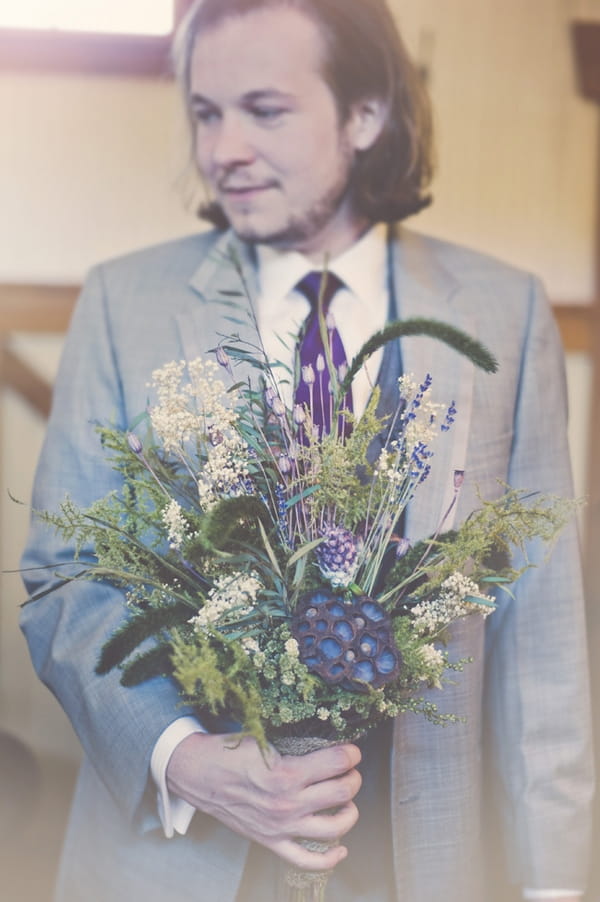 Groom holding bridal bouquet