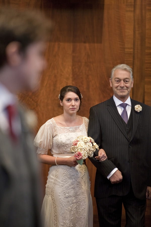 Bride walking with father into wedding ceremony