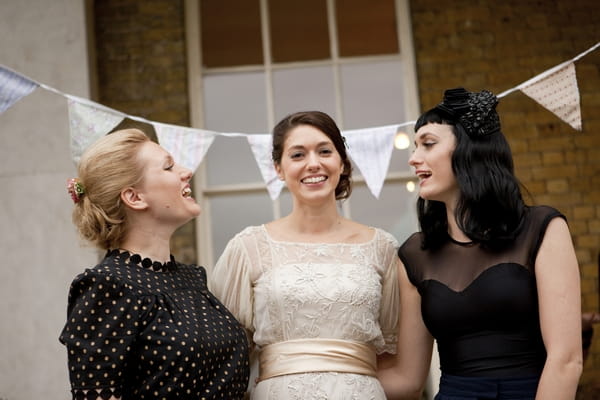 Bride with friends in front of bunting