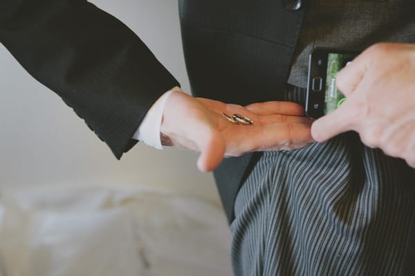 Best man putting rings into pocket