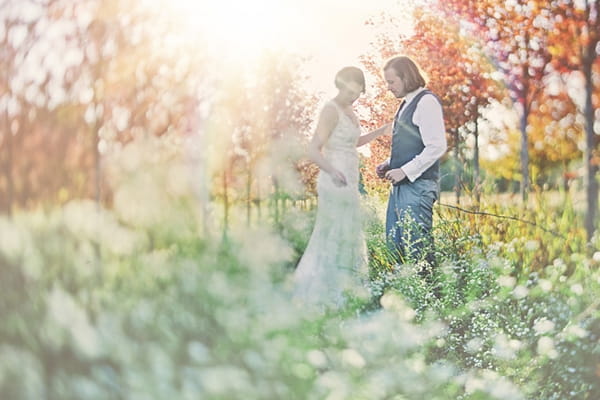 Bride and groom standing in foliage