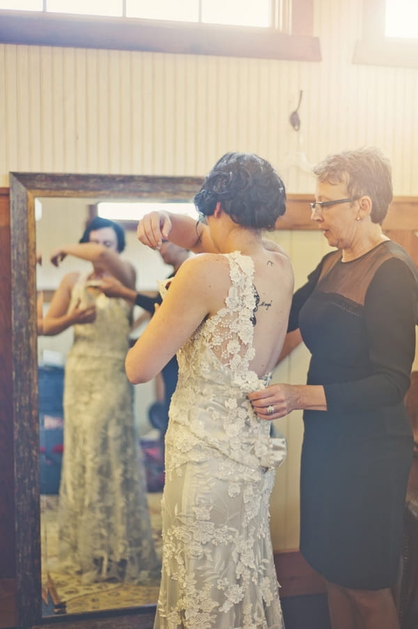 Bride putting on dress