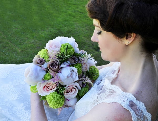 Bride sitting looking at bouquet