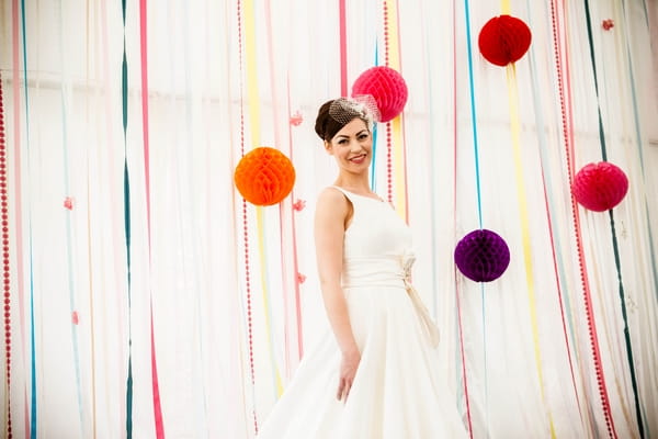 Bride in front of coloured streamers and pom poms