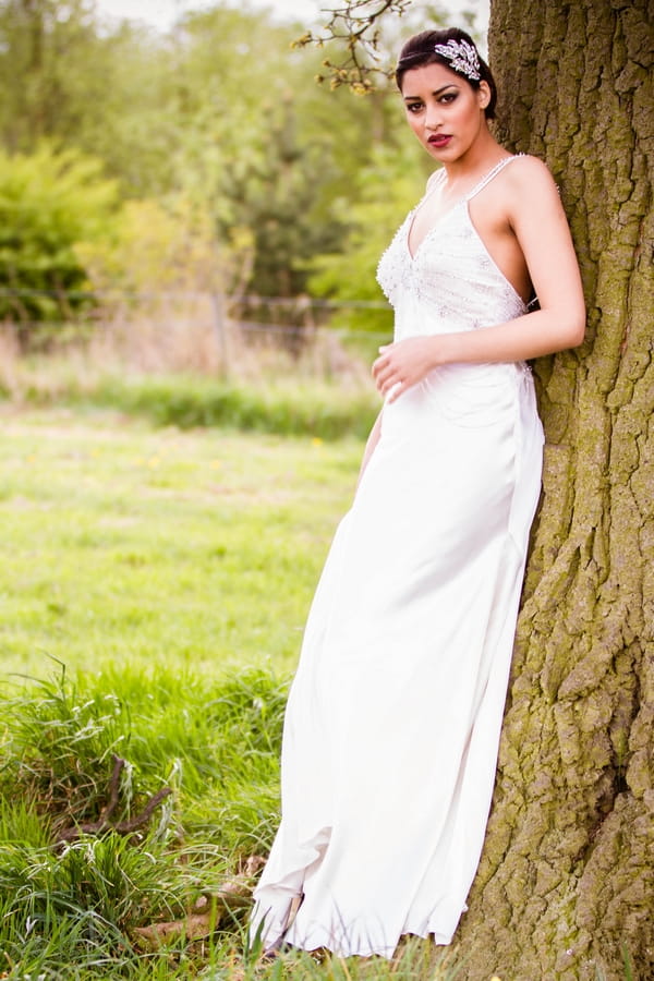 Bride leaning on tree