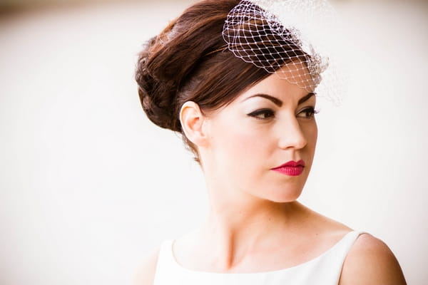 Bride wearing birdcage fascinator