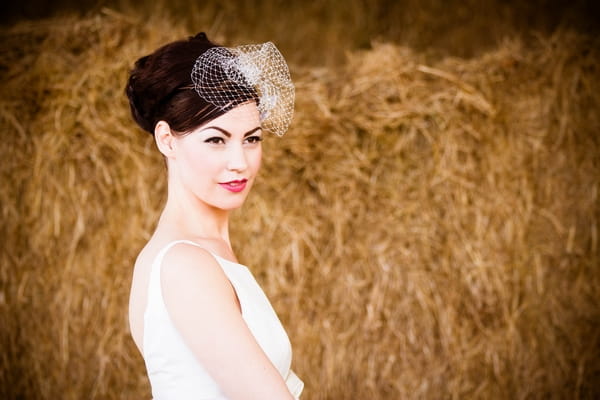 Vinatge bride standing in front of hay