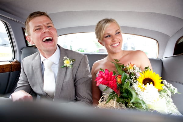 Bride and groom in back of wedding car