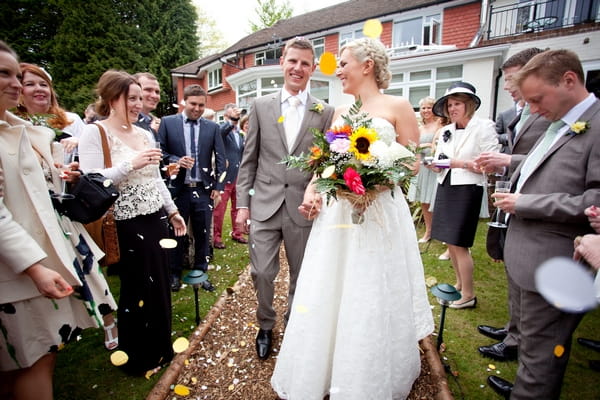 Bride and groom walking through confetti