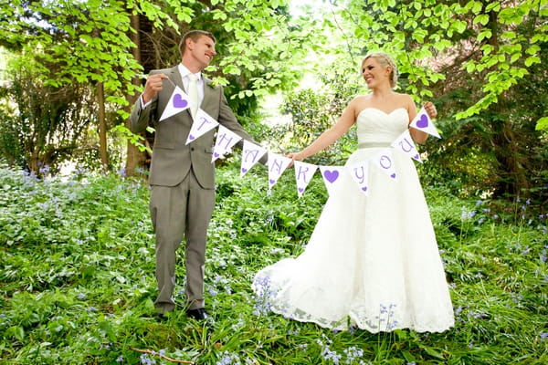 Bride and groom holding thank you bunting