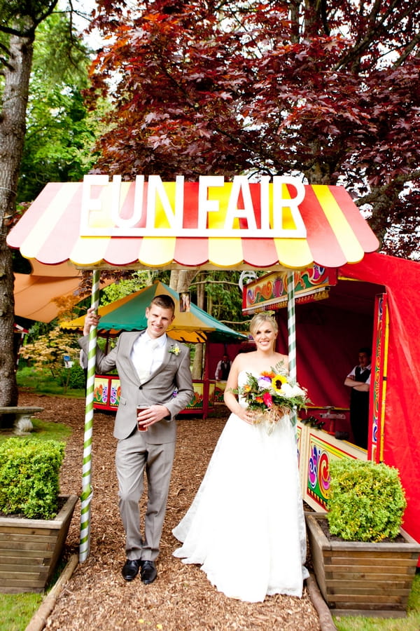 Bride and groom under funfair sign