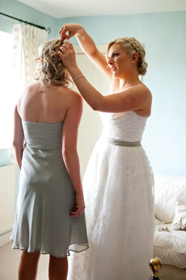 Bride helping bridesmaid with hair