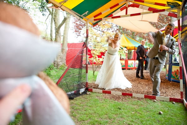 Bride and groom playing at coconut shy