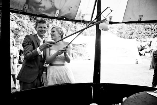 Bride and groom playing funfair fishing game